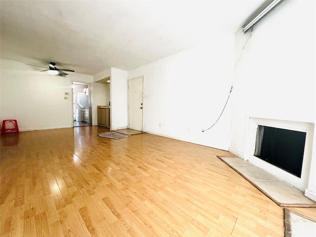 unfurnished living room featuring ceiling fan and wood-type flooring