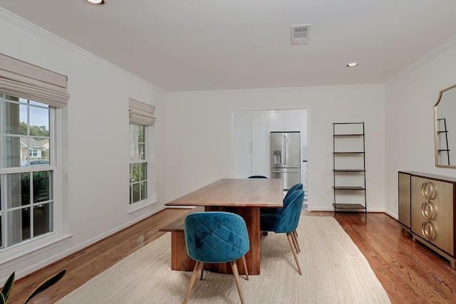 office with light hardwood / wood-style floors and crown molding