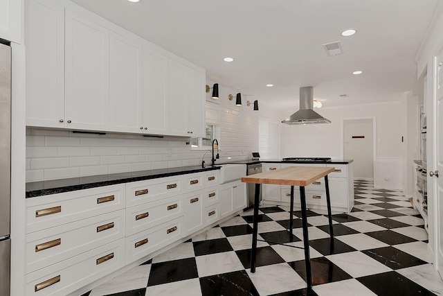 kitchen featuring island exhaust hood, tasteful backsplash, white cabinets, appliances with stainless steel finishes, and sink