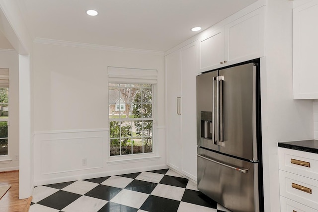 kitchen featuring high end fridge, white cabinetry, and crown molding