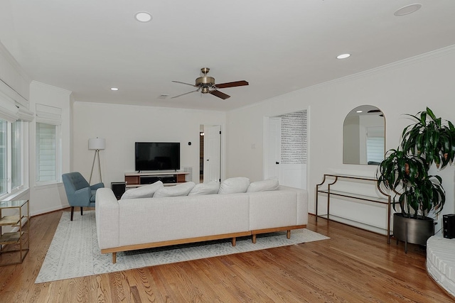 living room featuring ornamental molding, ceiling fan, and wood-type flooring