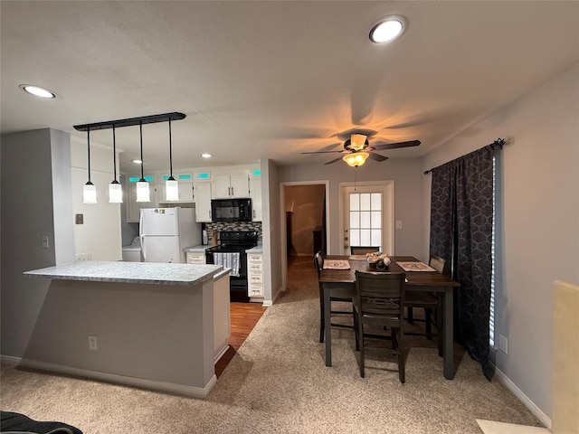 kitchen featuring white cabinets, black appliances, decorative backsplash, hanging light fixtures, and kitchen peninsula