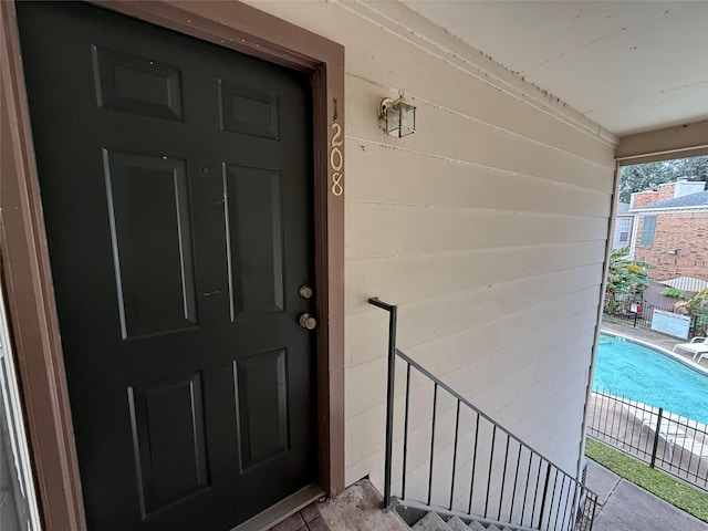 property entrance featuring a fenced in pool