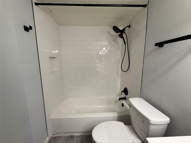 bathroom with toilet, tiled shower / bath combo, and wood-type flooring