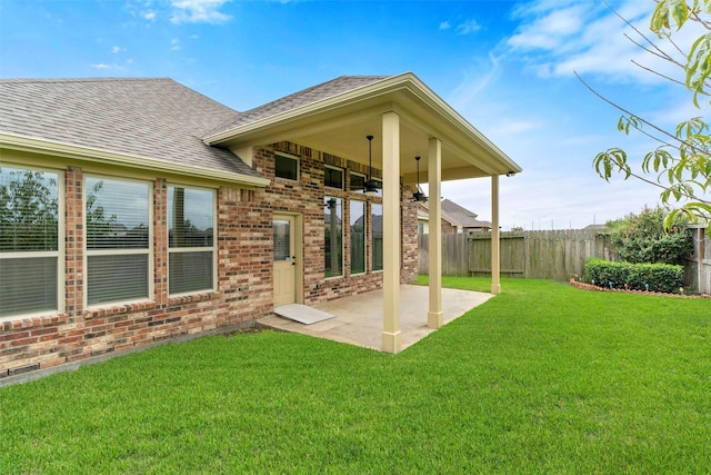 rear view of property featuring a patio area and a yard