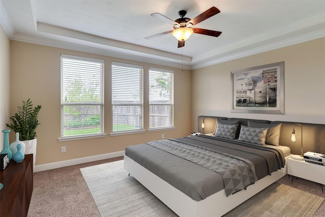 carpeted bedroom featuring ornamental molding, a raised ceiling, and ceiling fan