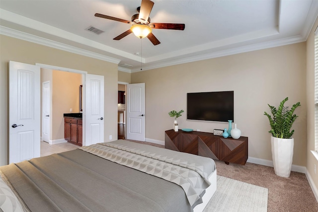 bedroom with connected bathroom, a raised ceiling, light carpet, and ceiling fan