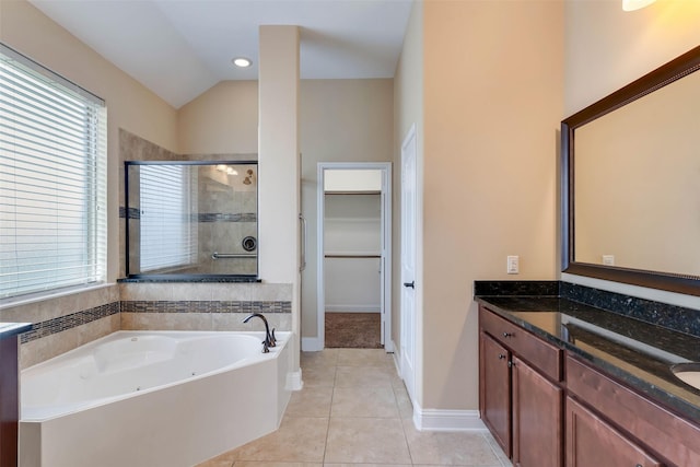 bathroom with lofted ceiling, shower with separate bathtub, vanity, and tile patterned floors