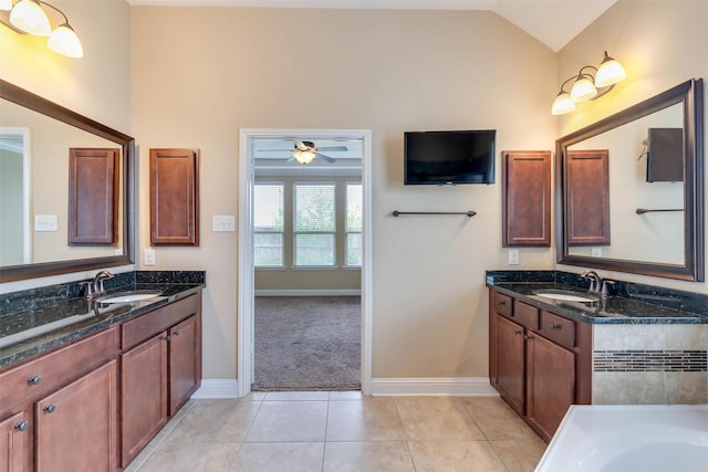 bathroom featuring a tub, vaulted ceiling, tile patterned flooring, ceiling fan, and vanity