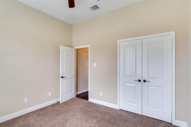 unfurnished bedroom with ceiling fan, a closet, and carpet floors