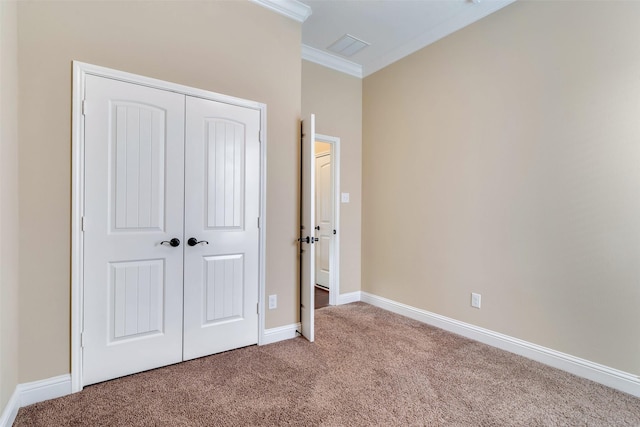 unfurnished bedroom featuring a closet, ornamental molding, and carpet floors