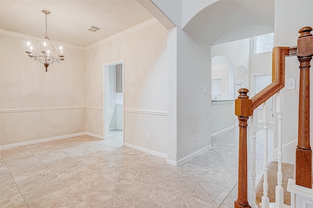 empty room with ornamental molding and a chandelier