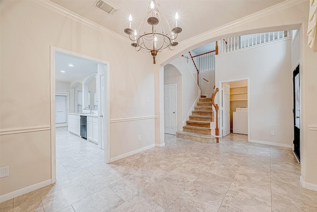 interior space featuring sink, an inviting chandelier, wine cooler, ornamental molding, and washer / dryer