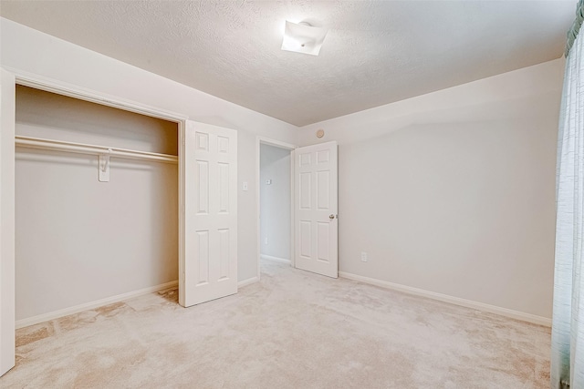 unfurnished bedroom with light colored carpet, a textured ceiling, and a closet