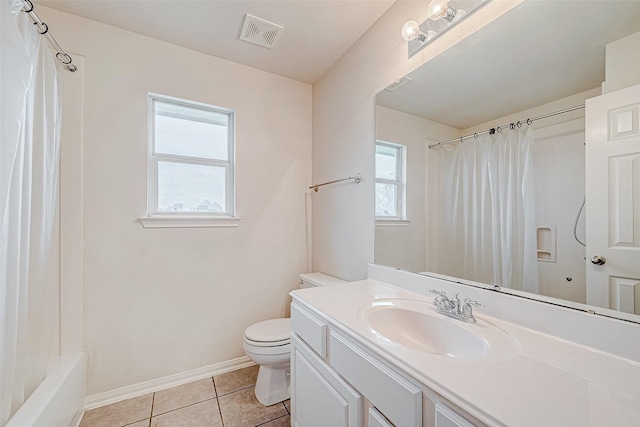 full bathroom with tile patterned floors, toilet, vanity, and a wealth of natural light