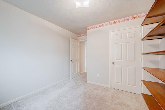 unfurnished bedroom with light carpet and a textured ceiling