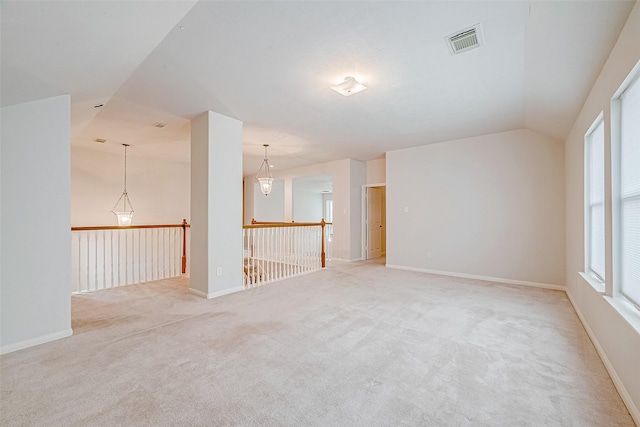 unfurnished room with lofted ceiling and light carpet