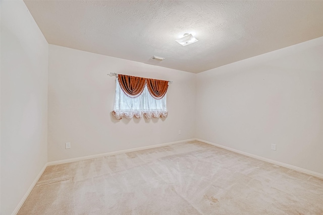 carpeted empty room featuring a textured ceiling