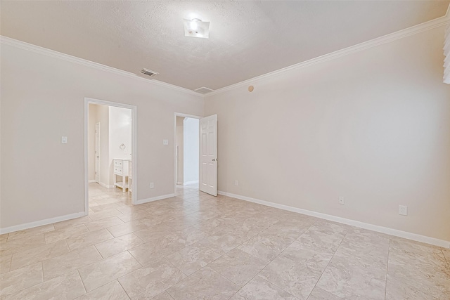 spare room featuring ornamental molding and a textured ceiling