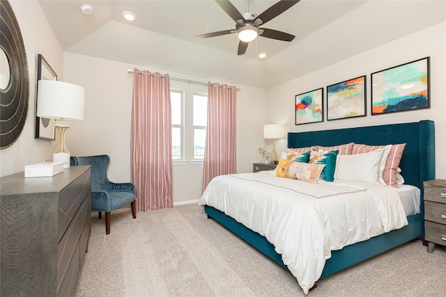 bedroom featuring vaulted ceiling, a raised ceiling, ceiling fan, and carpet flooring