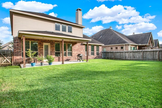 back of house with a patio area and a yard