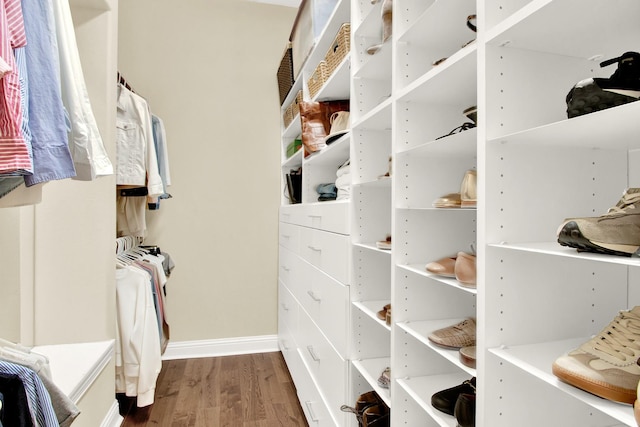 walk in closet with dark wood-type flooring