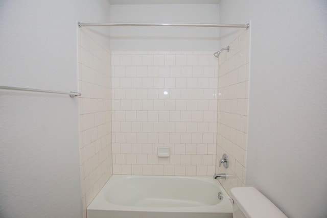 bathroom featuring toilet and tiled shower / bath combo