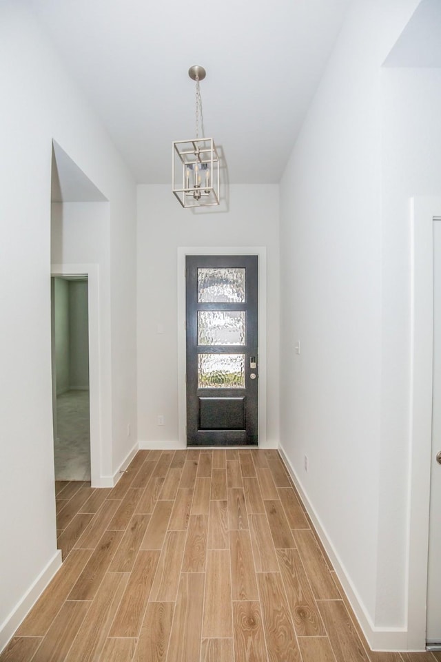 entrance foyer featuring an inviting chandelier and light hardwood / wood-style flooring