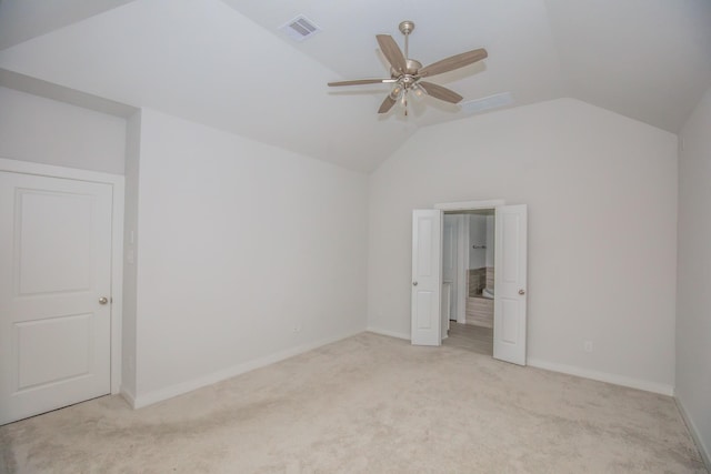 unfurnished bedroom featuring lofted ceiling, light colored carpet, and ceiling fan