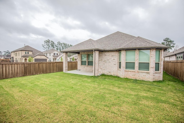 back of house with a lawn and a patio area