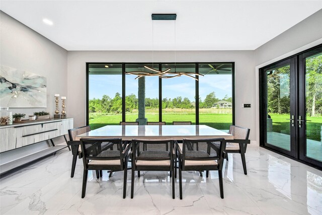 dining area with a notable chandelier, a wealth of natural light, and french doors