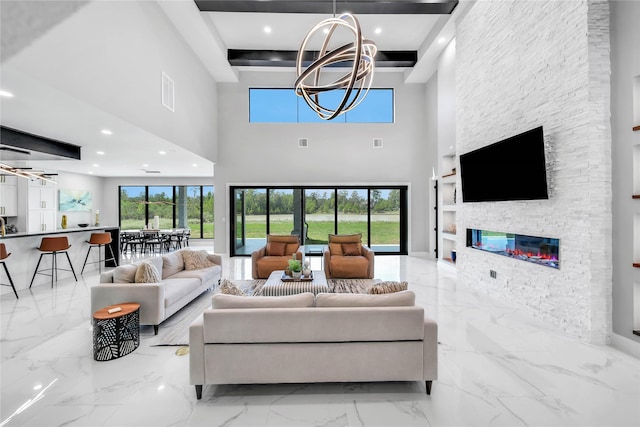 living room with a fireplace, a chandelier, and a wealth of natural light