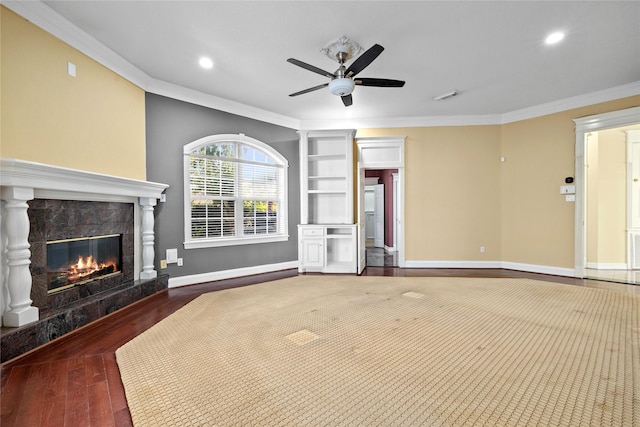 unfurnished living room featuring a premium fireplace, wood finished floors, visible vents, baseboards, and ornamental molding