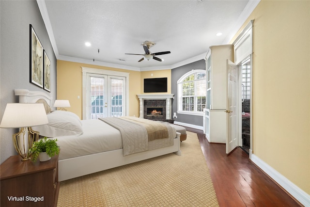 bedroom with access to exterior, crown molding, a high end fireplace, wood finished floors, and baseboards