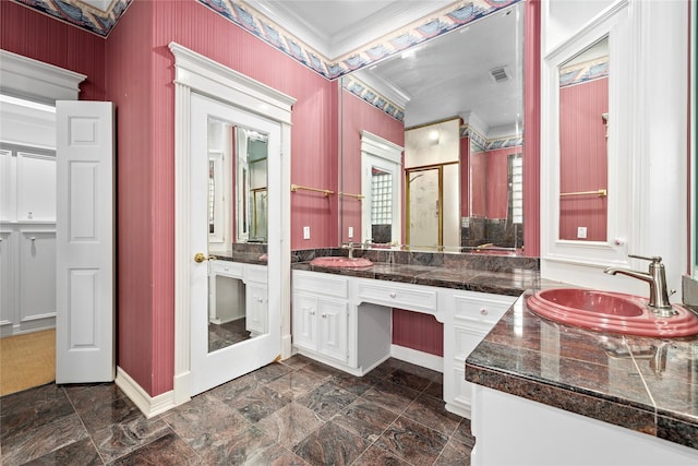 bathroom featuring double vanity, a stall shower, a sink, and crown molding