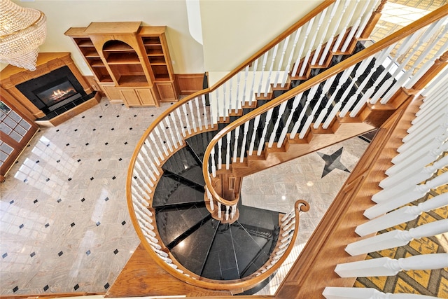 staircase featuring a glass covered fireplace