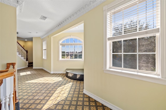 hallway featuring ornamental molding, stairway, visible vents, and baseboards