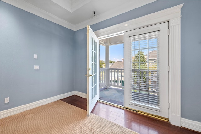 doorway featuring crown molding, baseboards, and wood finished floors