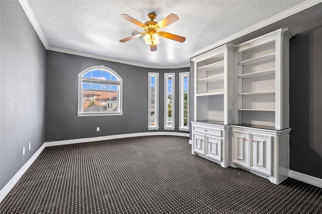 interior space with baseboards, a ceiling fan, a textured ceiling, crown molding, and dark carpet