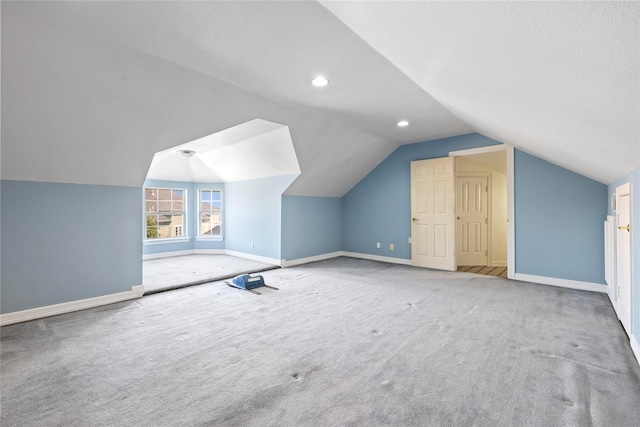 bonus room with vaulted ceiling, carpet floors, a textured ceiling, and baseboards