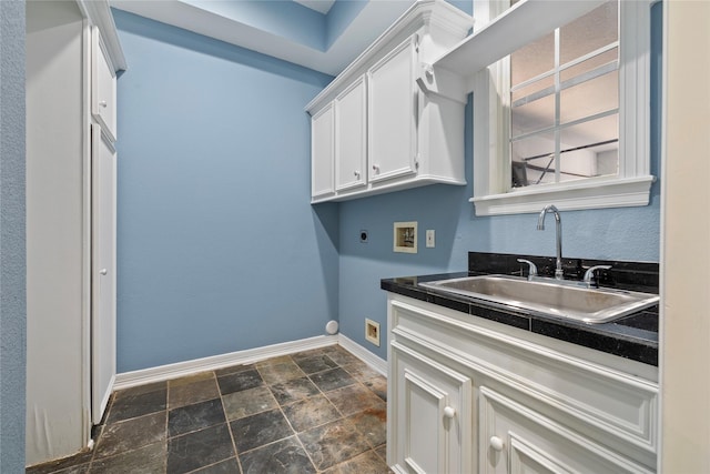 laundry area with baseboards, stone finish floor, hookup for a washing machine, electric dryer hookup, and a sink