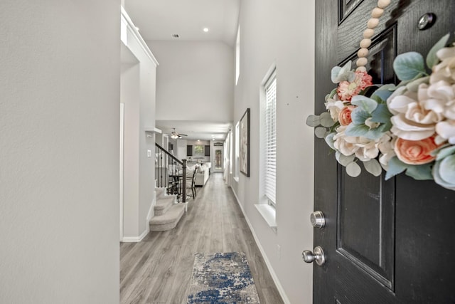 hallway with light hardwood / wood-style floors and a high ceiling