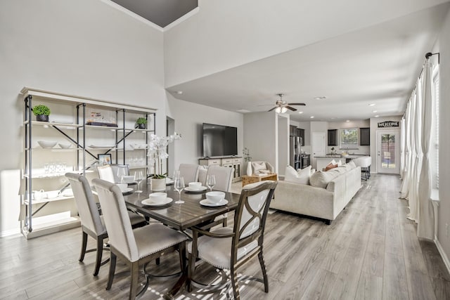 dining space featuring light wood-type flooring, ceiling fan, and ornamental molding