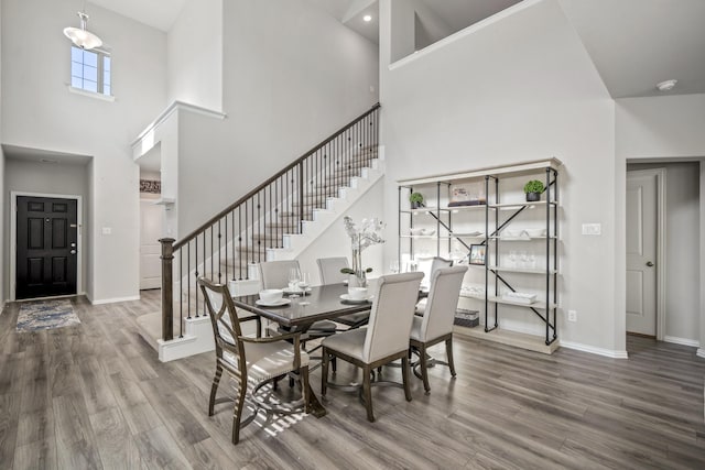 dining room featuring a high ceiling and wood-type flooring