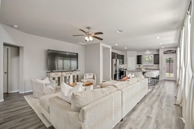 living room with ceiling fan and light hardwood / wood-style floors