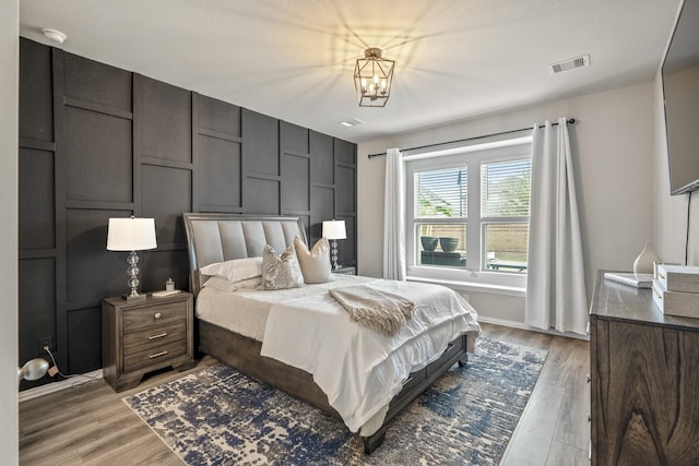 bedroom with a chandelier and light hardwood / wood-style floors