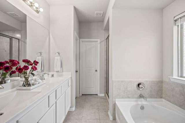 bathroom with vanity, tile patterned flooring, and plus walk in shower