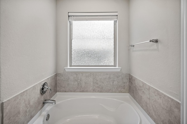 bathroom featuring a bath and a wealth of natural light