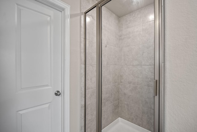 bathroom featuring a shower with door