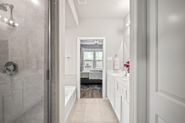 bathroom featuring tile patterned flooring, separate shower and tub, and vanity